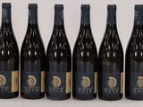 six bottles of wine are lined up in a row on a table
