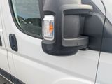 a side view mirror of a white van with the door open