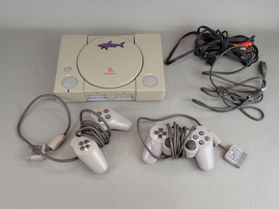 a game console with two controllers and a charger