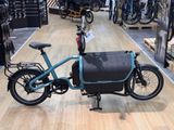 un vélo bleu avec un sac noir à l'arrière