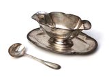 a silver plate with a spoon on it and a spoon on the plate