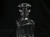 a clear glass bottle sitting on top of a black table
