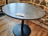 a table with a sign on it in front of a brick wall