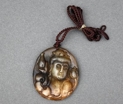 Gros plan sur un collier portant l'image d'une femme