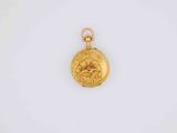 a close up of a gold pocket watch on a white surface