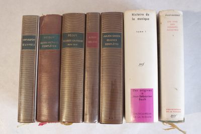 Quatre livres sont alignés sur une table, avec une étiquette rose