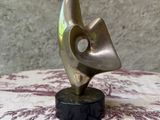 sculpture en bronze représentant une tête d'oiseau posée sur un socle en marbre