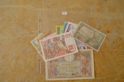 une liasse de billets posée par terre à côté d'un autocollant