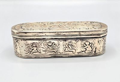 an old silver box with a design on it on a white surface