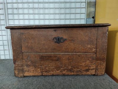 an old wooden chest with a drawer on top of it