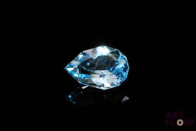 a close up of a blue topaz diamond on a black surface