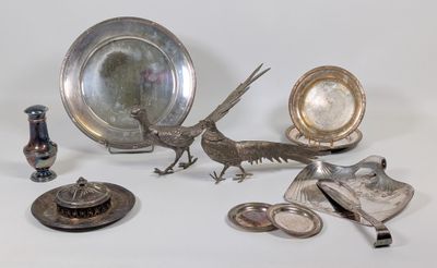 un plateau en argent orné d'un oiseau, à côté d'autres objets en argent