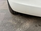 the rear end of a white car with a flat tire