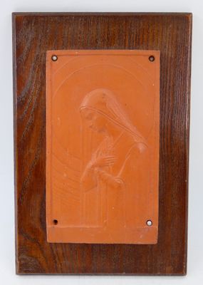 une image représentant une plaque sur laquelle figure une femme tenant un bébé dans ses bras
