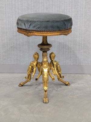 an image of a gold stool with a blue cushion on top of it