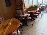 many tables and chairs in this restaurant with a lot of windows
