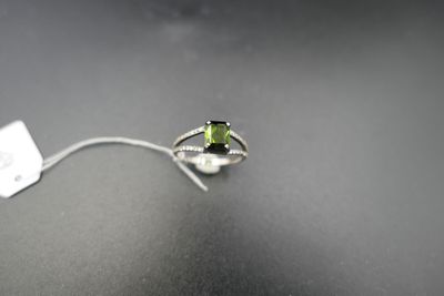 Gros plan sur une bague ornée d'une pierre verte