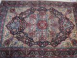 un tapis oriental avec un motif de médaillon sur fond blanc