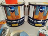 two cans of paint sitting on a table next to a roll of tape