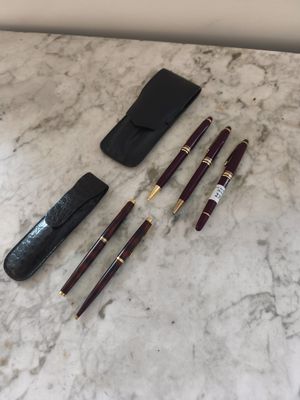 quelques stylos et un étui sont posés sur une table en marbre