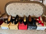 several pairs of women ' s shoes sitting on top of boxes on a chair