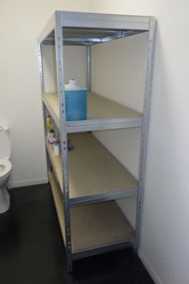 une salle de bains équipée de toilettes et d'une étagère