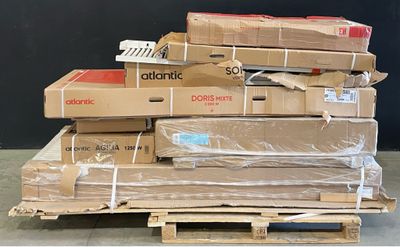 une pile de cartons posée sur une palette devant un mur noir