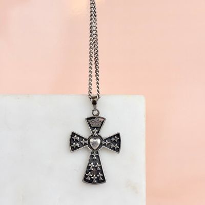 une croix noire et blanche surmontée d'une couronne, posée sur un bloc de marbre
