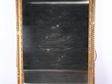 an image of a gold framed mirror sitting on top of a table