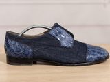 the shoe is made of denim and has a blue snake print on it