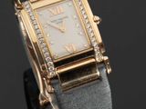 une montre en or sertie de diamants, posée sur un fond noir