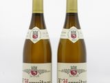 two bottles of wine sitting next to each other on a white surface