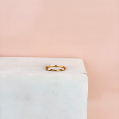 une bague en or posée sur un bloc de marbre