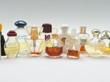 many different bottles of perfume on a white surface