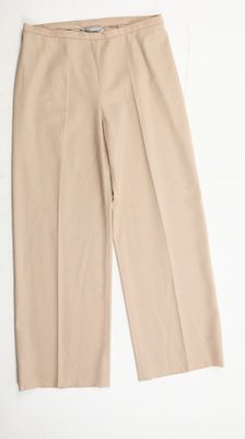 un gros plan d'un pantalon beige posé sur une surface blanche