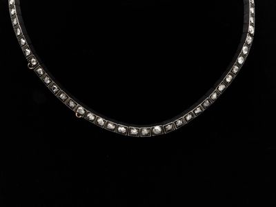 une photo en noir et blanc d'un collier sur fond noir