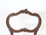 une chaise en bois avec un dossier sculpté et une assise en bois