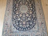 un tapis bleu et blanc posé sur un parquet, à côté d'un chat