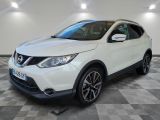 une Nissan QX-V blanche garée sur un sol à damier