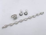 three pieces of silver jewelry sitting on top of a white surface