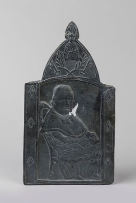 une plaque en pierre noire représentant un homme tenant une colombe sur ses genoux