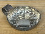 a metal bowl on a wooden table with water in it