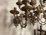 a lot of antique chandeliers hanging on the wall