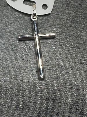 une croix posée par terre à côté d'une paire de ciseaux