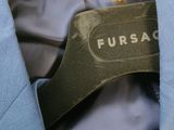 blue jacket with fursac label on it hanging on a hanger