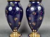 pair of blue vases with gold stars on them on a gray background