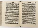 a book open to a page of text on a white surface