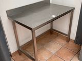 a table with a metal top in the corner of a room
