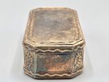 an old silver box with a lid sitting on a white surface