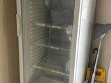 a glass door refrigerator sitting in the corner of a room